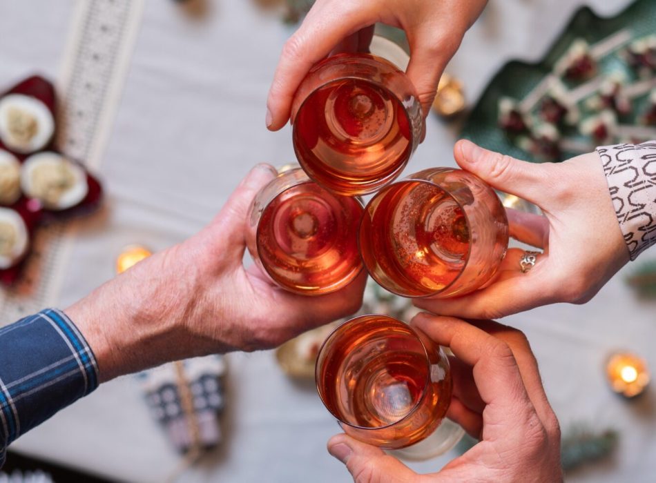 top view of people holding wine glasses over festive table