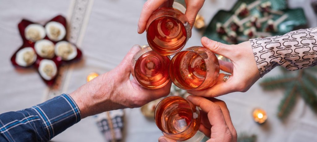 top view of people holding wine glasses over festive table