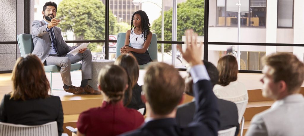 Male and female seminar speakers take question from audience