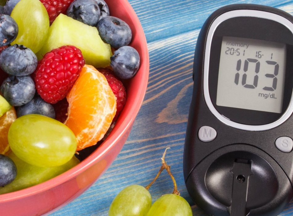 Fresh fruit salad and glucometer with result of measurement sugar level, concept of diabetes, diet, slimming, healthy lifestyles and nutrition