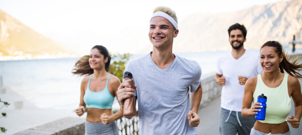 Healthy fit people running and jogging together in summer sunny nature