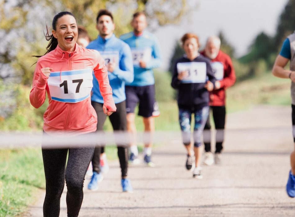 A large group of active multi generation people running a race competition in nature.