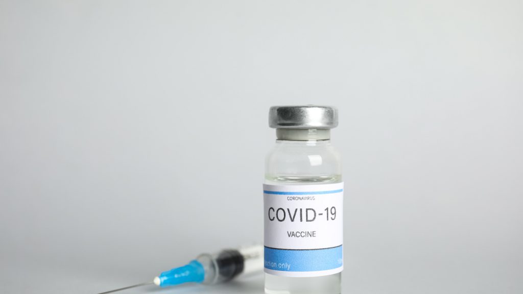 Vial,With,Coronavirus,Vaccine,And,Syringe,On,Light,Background